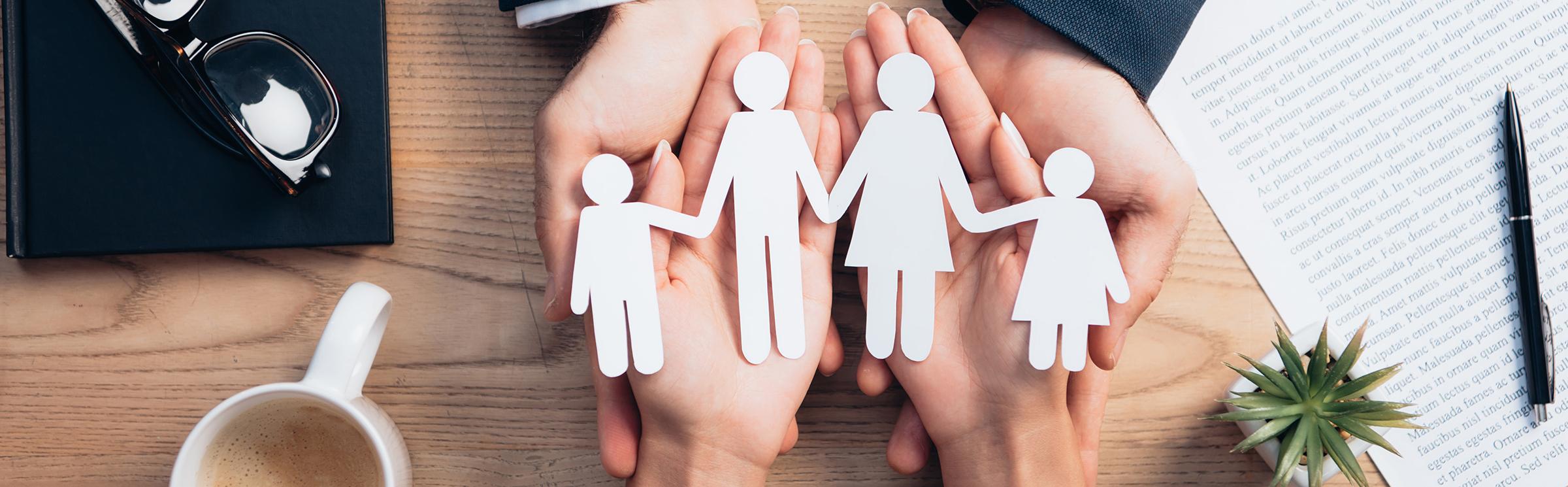 hands-holding-paper-cutout-family-on-wooden-desk-2026-01-06-00-28-12-utc